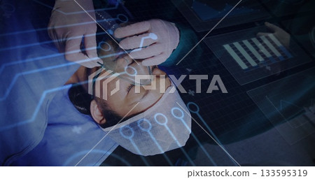 Positioning oxygen mask over male patient face in operating room, with digital interface overlay Positioning oxygen mask over male patient face in operating room, with digital interface overlay 133595319
