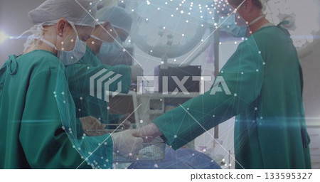 Performing surgery three surgeons operating on patient under blue drape in surgery room, with tools 133595327