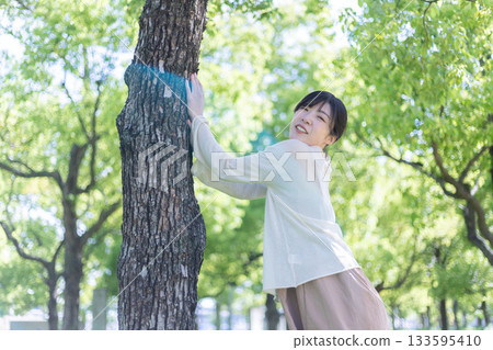 A woman who takes a deep breath at a park 133595410