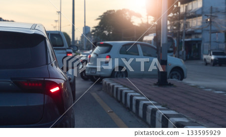 Rear side of car with turn on brake light. Waiting in line to make a U-turn in front. A blurry image of a white car making a U turn. Blurred of city and sunlight on the sky. Rear side of car with turn on brake light. Waiting in line to make a U-turn in front. A blurry image of a white car making a U turn. Blurred of city and sunlight on the sky. 133595929