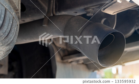 Underneath the car. Exhaust pipe cover for automobiles. Part of the car equipment is covered with dust. making the object cloudy. 133595932