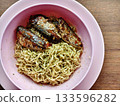 Instant noodles with spicy canned fish in a pink bowl, simple budget meal. 133596282