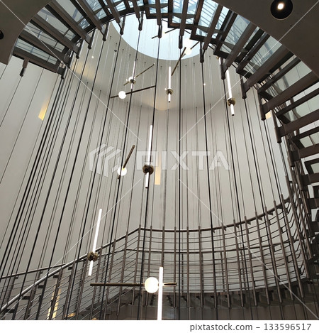 Spiral staircase with a contemporary design features thin metal steps and a sleek railing Spiral staircase with a contemporary design features thin metal steps and a sleek railing 133596517