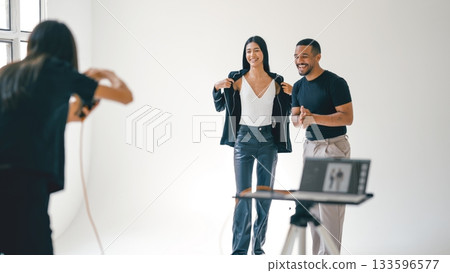 Photographer taking photos of fashion models in professional studio Photographer taking photos of fashion models in professional studio 133596577