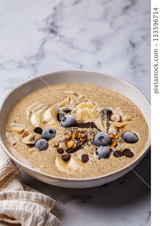 Chocolate smoothie bowl with banana, blueberries and nuts. Chocolate smoothie bowl with banana, blueberries and nuts. 133596714