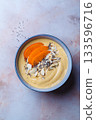 Persimmon smoothie bowl with chia seeds and nuts. 133596716