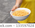 Spicy instant noodles bowl and hand 133597028