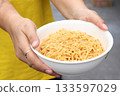 Spicy instant noodles bowl and hand 133597029