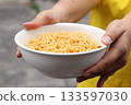 Spicy instant noodles bowl and hand 133597030