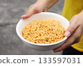 Spicy instant noodles bowl and hand 133597031