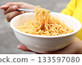 Spicy instant noodles bowl eating and hand 133597080
