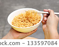 Spicy instant noodles bowl eating and hand 133597084