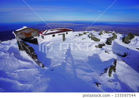 Shadow of a climber standing on the summit of Mt. Iwaki in winter Shadow of a climber standing on the summit of Mt. Iwaki in winter 133597544