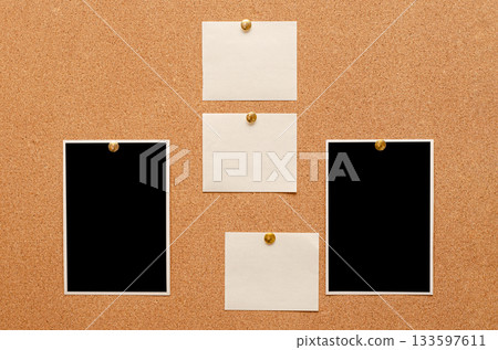 Blank paper notes and an empty photo are pinned to a cork board. The concept of detective investigation. 133597611