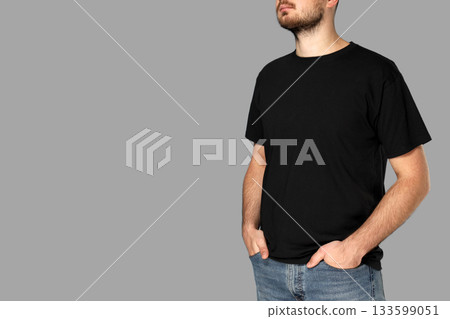 Man models simple black t-shirt with hands in pockets 133599051