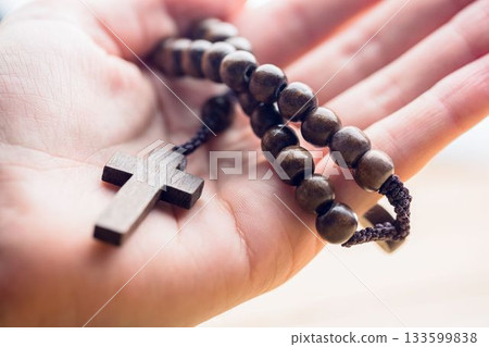 Hand holding rosary beads 133599838