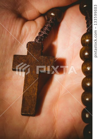 Hand holding rosary beads 133599883