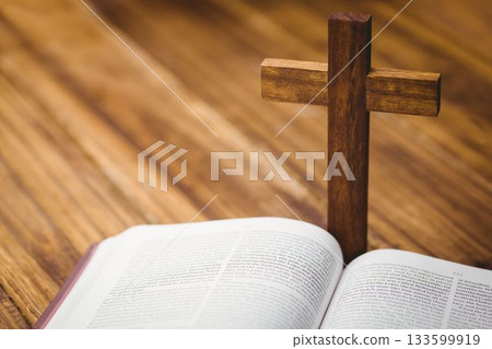 Wooden cross by bible on hardwood flooring 133599919