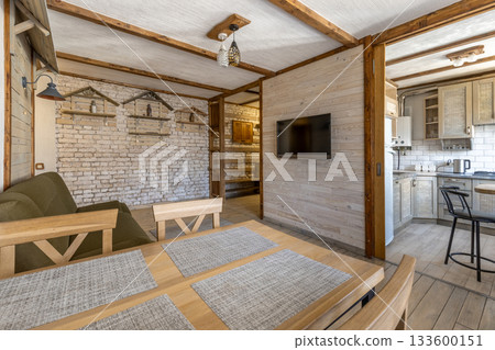 Bright Rustic Living Room and Kitchen Interior with Wooden Furniture Bright Rustic Living Room and Kitchen Interior with Wooden Furniture 133600151