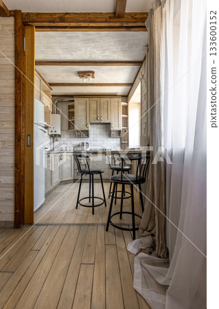 Bright Rustic Kitchen Interior with Wooden Cabinets and Bar Stools 133600152