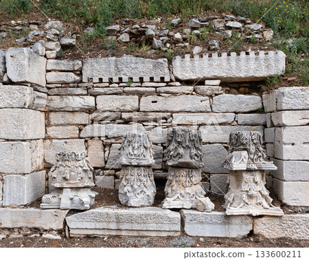 Ruins of ancient column capitals and a stone wall at Ephesus, a UNESCO World Heritage site in Selcuk, Turkey. 133600211