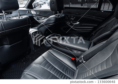 Luxury car interior showing sleek black leather seats and modern design features in a city setting Luxury car interior showing sleek black leather seats and modern design features in a city setting 133600648