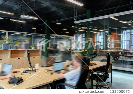 Modern office space with employees working in a collaborative environment during daytime hours 133600675