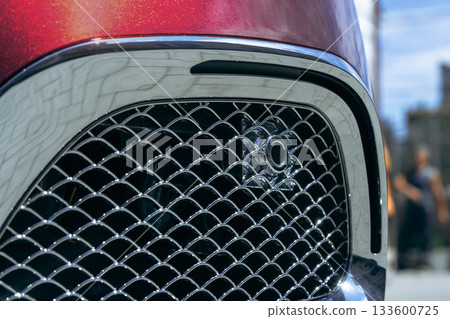Close view of a shiny car grill showcasing modern design features and attention to detail Close view of a shiny car grill showcasing modern design features and attention to detail 133600725