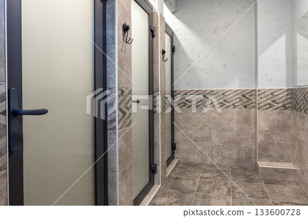 Modern restroom with stylish stalls and elegant tile design in a clean space Modern restroom with stylish stalls and elegant tile design in a clean space 133600728