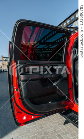 Bright red truck door open, showcasing interior design and features at auto show Bright red truck door open, showcasing interior design and features at auto show 133600785
