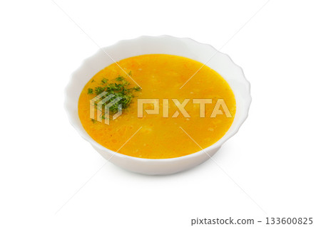 Yellow lentil soup topped with fresh herbs in a white bowl Yellow lentil soup topped with fresh herbs in a white bowl 133600825