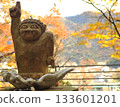 A statue of Kinuta pointing to the sky with autumn leaves at Kinugawa Onsen behind him 133601201