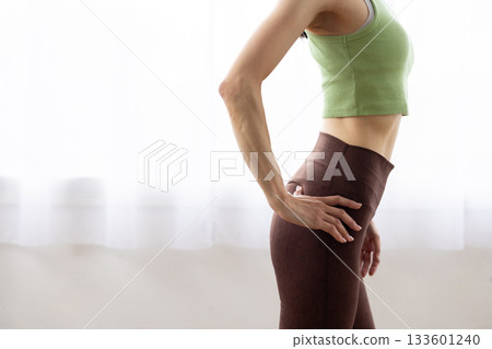 Close-up of a woman's toned abdomen in fitness wear 133601240