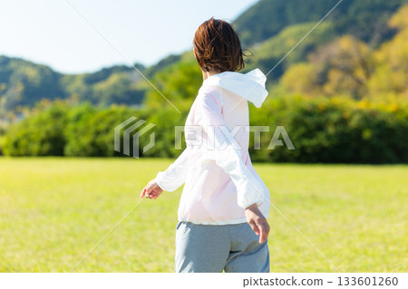 Middle-aged woman doing stretching exercises outdoors Middle-aged woman doing stretching exercises outdoors 133601260