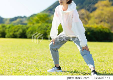 Middle-aged woman doing stretching exercises outdoors Middle-aged woman doing stretching exercises outdoors 133601464