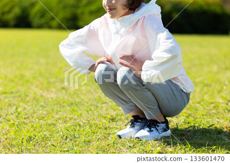 Middle-aged woman doing stretching exercises outdoors 133601470