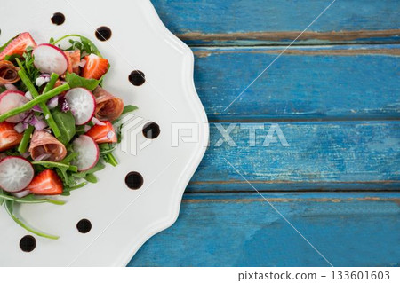 Fresh salad in plate served on blue table 133601603