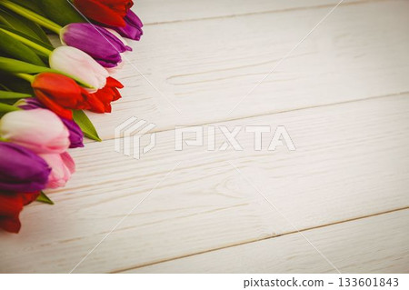 Multicolored tulip bouquet is being shown in flat design on whitewashed wooden tabletop, copy space 133601843