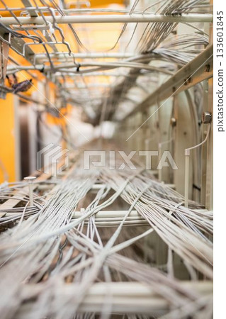 White and gray network cables are stretching along metal trays in 3D render server room 133601845