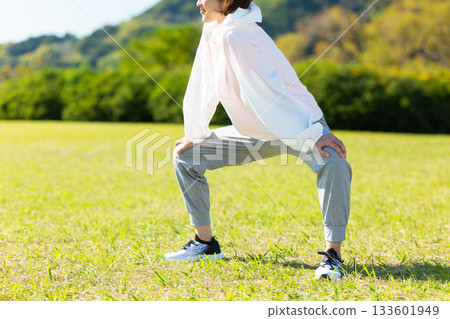 Middle-aged woman doing stretching exercises outdoors 133601949