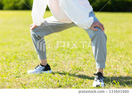 Middle-aged woman doing stretching exercises outdoors 133601980