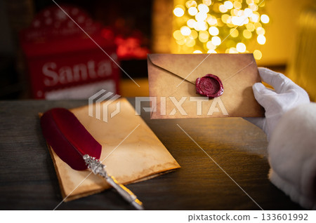 Close up of Santa Claus hands writing letter on Worden desk with copy space Close up of Santa Claus hands writing letter on Worden desk with copy space 133601992