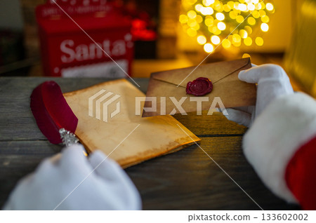 Close up of Santa Claus hands writing letter on Worden desk with copy space Close up of Santa Claus hands writing letter on Worden desk with copy space 133602002