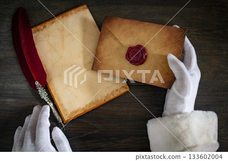 Close up of Santa Claus hands writing letter on Worden desk with copy space 133602004