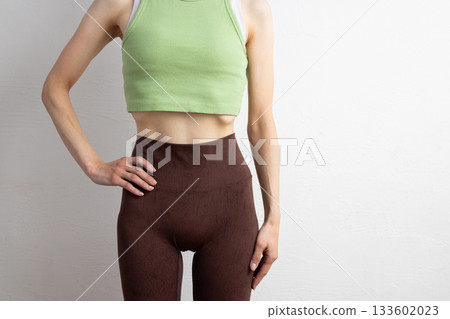 特寫鏡頭：一位身穿運動服的女性線條優美的腹部 133602023