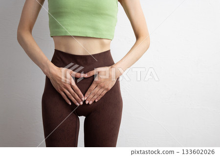 一位身穿運動服的女性的特寫鏡頭，顯示了她的骨盆位置 133602026