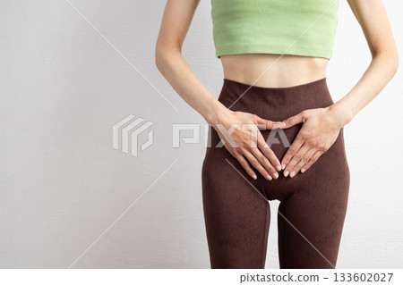 一位身穿運動服的女性的特寫鏡頭，顯示了她的骨盆位置 133602027