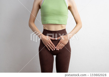 一位身穿運動服的女性的特寫鏡頭，顯示了她的骨盆位置 133602028