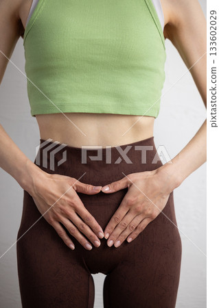 一位身穿運動服的女性的特寫鏡頭，顯示了她的骨盆位置 133602029