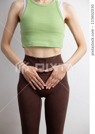 一位身穿運動服的女性的特寫鏡頭，顯示了她的骨盆位置 133602030